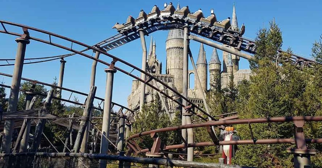 A roller coaster twists and loops before a majestic castle