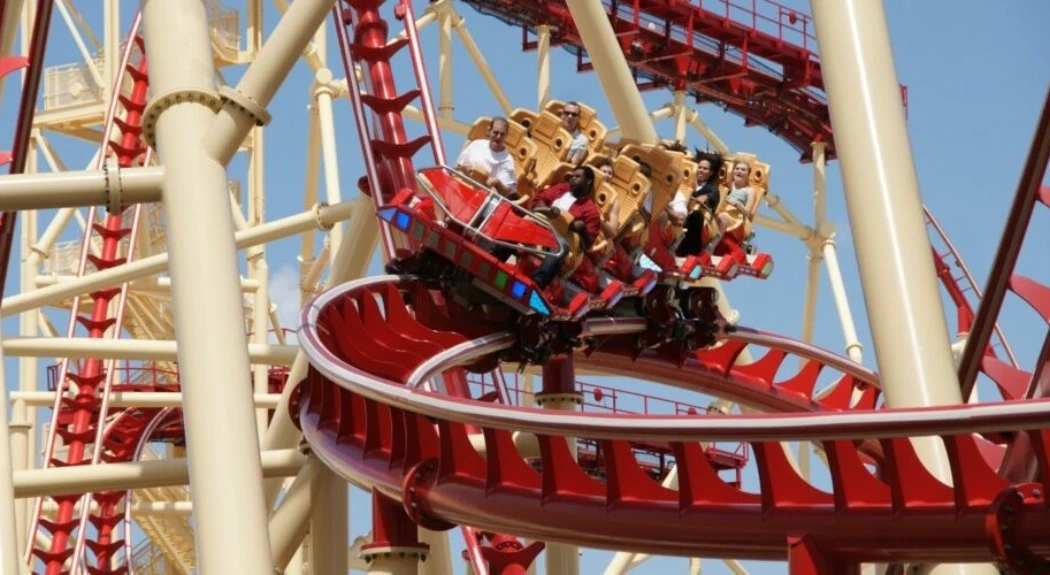 A red color roller coaster thrilling riders as they scream excitedly