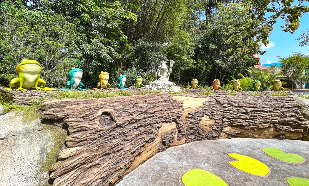 Colorful frog sculptures on a log