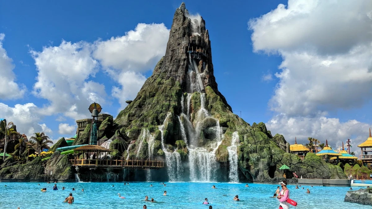 People are relaxing by the pool with a volcano mountain in the backdrop