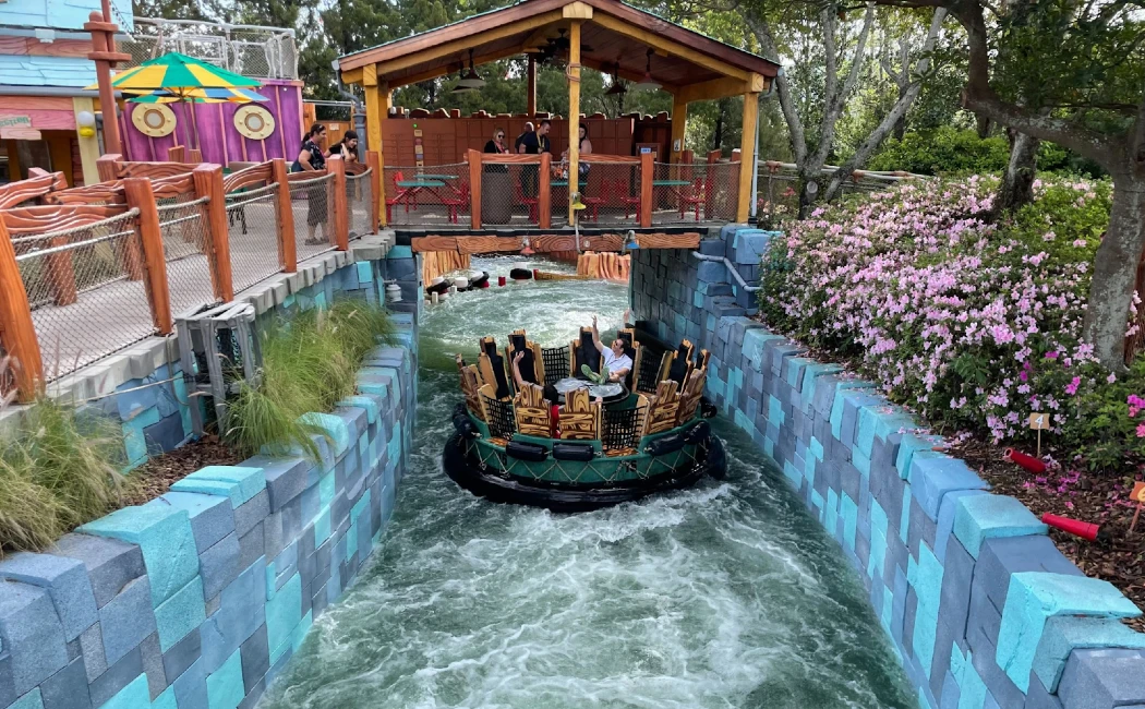 A colorful log flume ride navigates through a winding waterway