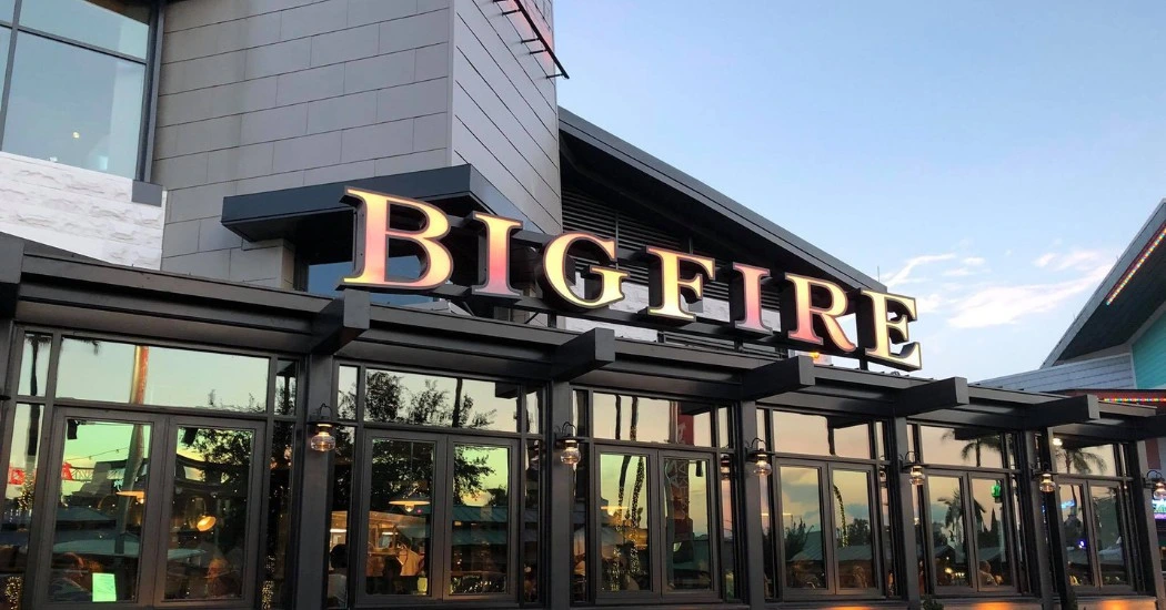 The exterior of Bigfire restaurant, showcasing its large illuminated sign and modern architecture
